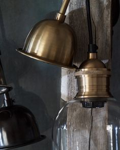 two lights are hanging from the side of a wooden wall next to a lamp shade