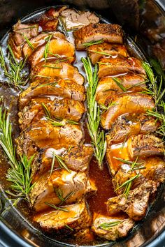 pork chops with gravy and rosemary in a slow cooker, ready to be cooked