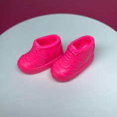 a pair of pink shoes sitting on top of a white table