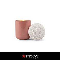 a candle that is sitting in front of a white background with the words macy's on it