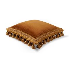 a brown pillow with tassels on it sitting on top of a white floor