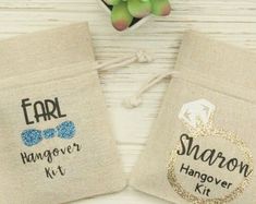 two small bags with the words, ear hanger and bow tie embroidered on them