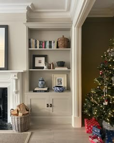 a living room with a christmas tree in the corner and other decorations on the shelves