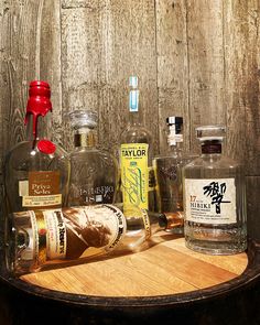 various liquor bottles sitting on top of a wooden table