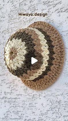 two circular crocheted coasters on a white wall with the words hiwaya design