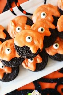 cookies decorated to look like dogs with oreos and eyes on them, sitting on a white platter