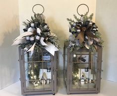 two metal lanterns decorated with bows and greenery