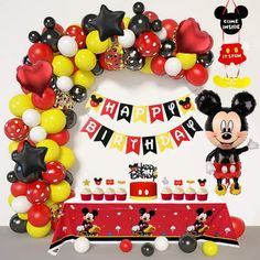 a mickey mouse birthday party with balloons and decorations