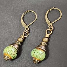 "If you love vintage things, and rustic/retro style, you will love adding these earrings to your collection. Hand crafted with handmade ceramic clay beads in speckled green round beads. Accent beads are metal. These earrings are so cute! Ceramic beads are about 9mm These earrings are about 1.5 inches long including the ear wires.  The metal is antiqued bronze colored. The earwires are alloy (nickel-free, lead-free, cadmium-free) which is good for most people with sensitive ears. Ear wires are le Handmade Vintage Beaded Earrings With Round Beads, Vintage Handmade Beaded Earrings, Vintage Everyday Earrings With Ear Wire, Nickel-free Vintage Drop Beaded Earrings, Vintage Nickel-free Drop Beaded Earrings, Vintage Single Earring For Everyday Wear, Vintage Single Earring For Everyday, Vintage Everyday Earrings, Handmade Vintage Beaded Drop Earrings