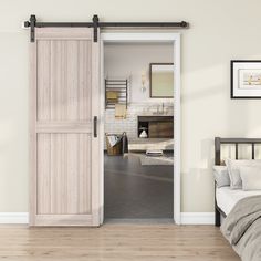 an open door leading to a bedroom with a bed in the foreground and a fireplace in the background