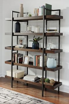 a bookshelf with several shelves and vases on top of it in a living room