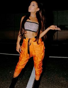 a woman in an orange pants and crop top