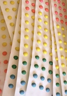 colorful polka dots are arranged on white paper