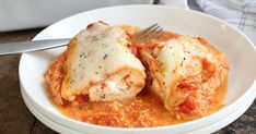 a white bowl filled with meat covered in tomato sauce and parmesan cheese on top