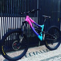 a colorful bicycle parked next to a fence