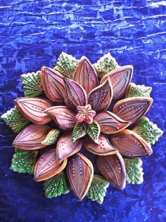 a flower shaped cookie sitting on top of a blue surface