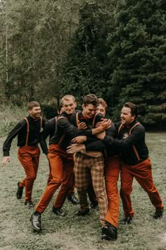 a group of men standing next to each other on top of a field