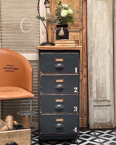 an old chest of drawers with flowers in a vase on top and other items around it