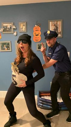 a man and woman dressed up as police officers in the bathroom with halloween decorations on the wall behind them