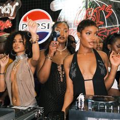 a group of young women standing next to each other in front of a pepsi sign