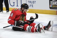 a hockey player is sitting on the ice