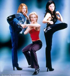 three women are posing in front of a blue background