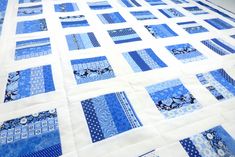 a blue and white quilt is laying on the floor