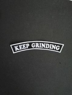 the keep grinding sticker is white and black