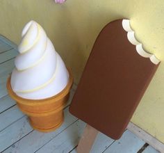 an ice cream cone sitting next to a brown and white container on a wooden floor