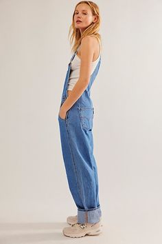 The perfect vintage-inspired overalls from Levi's, this distressed style is featured in a classic bib-and-brace silhouette with front pouch pocket and relaxed, straight leg design. * Adjustable straps * Four pocket design * Side button closures * Logo patch detail at front | Levi's Vintage Overalls at Free People in Medium Wash, Size: XL Womens Overalls Outfits, Levis Overalls, Long Overalls, Cotton Overalls, Vintage Overalls, Style Overalls, Overalls Outfit, Sporty Sneakers, Bib Overalls