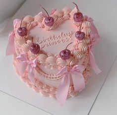 a heart shaped birthday cake with pink decorations