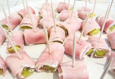 small appetizers with toothpicks are arranged on a white platter, ready to be eaten