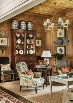 a living room filled with furniture next to a wooden paneled wall covered in pictures