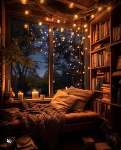 a bedroom with bookshelves and lights strung from the ceiling, windows to the outside