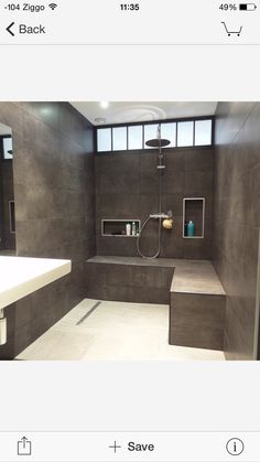 a bathroom with a sink, mirror and shower head mounted to the side of the wall