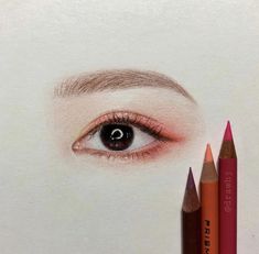 an eye with two pencils in front of it and the image of a woman's face