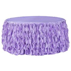 a round table covered in purple ruffles on top of a white surface,