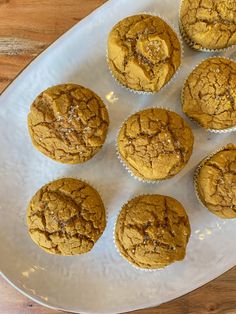 a white plate topped with muffins on top of a wooden table