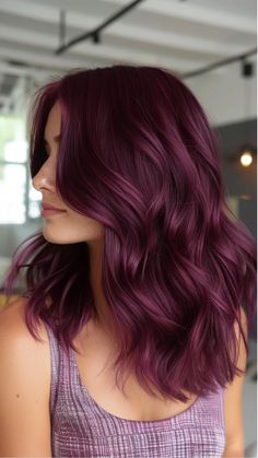 Woman with shoulder-length wavy aubergine-colored hair in a modern setting. Wine And Black Hair, Berry Plum Hair Color, Hair Color Ideas Plum, Cherry Plum Hair Color, Plum Color Hair, Cherry Burgundy Hair, Purple Wine Hair, Black Cherry Hair Color Dark, Dark Red Violet Hair