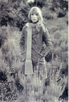 an old photo of a woman standing in a field with her hands on her hips