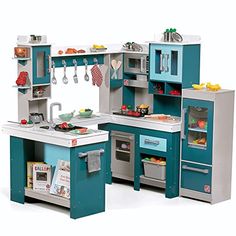 a toy kitchen with blue cabinets and white counter tops, including a stove top oven