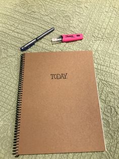 a notebook with the word today written on it next to a pen