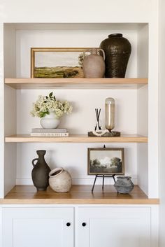 shelves with vases and pictures on them