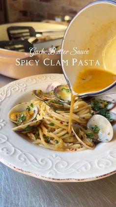 clam chowee being poured onto a plate of pasta with clams and sauce