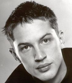 a black and white photo of a young man with short hair wearing a polo shirt