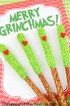 four green grass sticks with red hearts on them and the words merry grinichmas