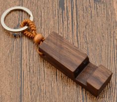 a wooden keychain with a metal ring on it sitting on a wood floor