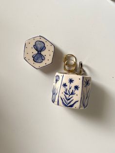 two small blue and white vases sitting on top of a table