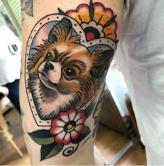 a dog with flowers on its head is shown in this tattoo