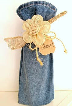 a denim bag with a flower on it and a name tag attached to the side